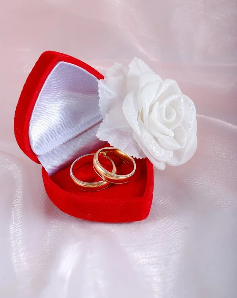 Two wedding rings in red case and a rose — Stock Photo, Image