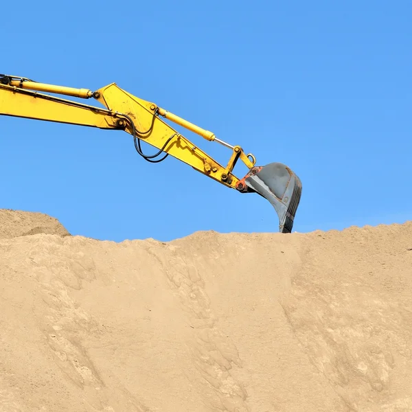 Новый жёлтый экскаватор работает на песчаных дюнах — стоковое фото
