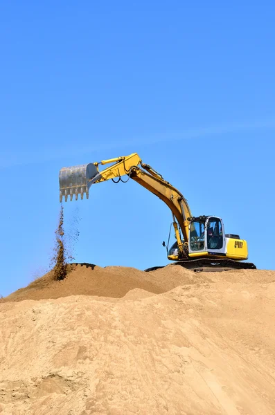 Nueva excavadora amarilla trabajando en dunas de arena — Foto de Stock