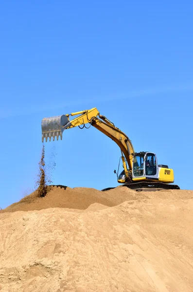 Nueva excavadora amarilla trabajando en dunas de arena —  Fotos de Stock