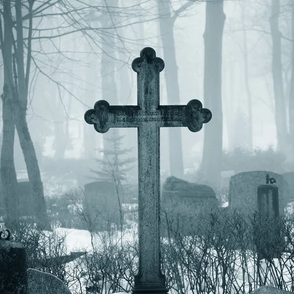 Крест в тумане на кладбище — стоковое фото