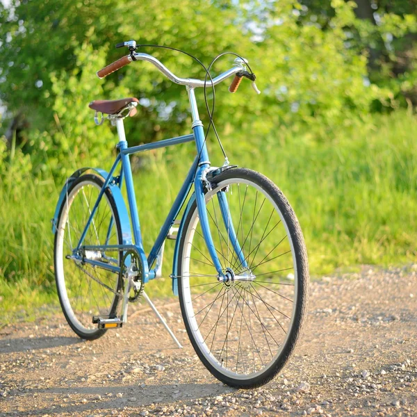 Παλιά εκλεκτής ποιότητας μπλε ποδήλατο σε ένα δρόμο σε μια αγροτική περιοχή — Φωτογραφία Αρχείου