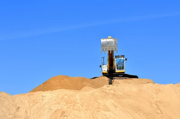 New yellow excavator working on sand dunes — Stock Photo, Image