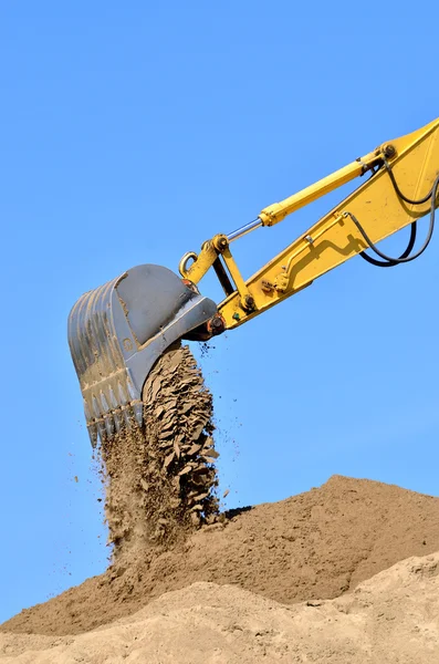 Nieuwe gele graafmachine bezig met zandduinen. Scoop close-up — Stockfoto