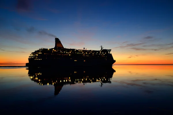 Färjan kryssningsfartyg med sin reflektion i den färgglada solnedgången — Stockfoto