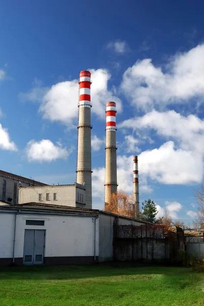 Industrial factory producing electricity with pipes against blue sky — Stock Photo, Image