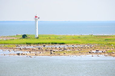 Mavi denizi kayalık adanın beyaz deniz feneri