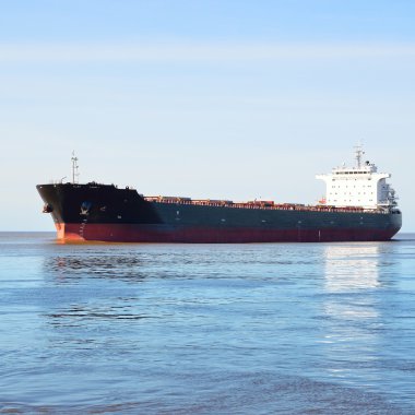 kargo gemisi durgun suda hareket ediyor.