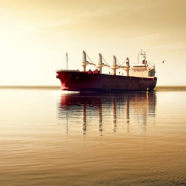 kargo gemisi durgun suda hareket ediyor.