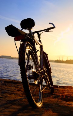 renkli günbatımı ve endüstriyel bağlantı noktası arka plan karşı Bisiklet siluet