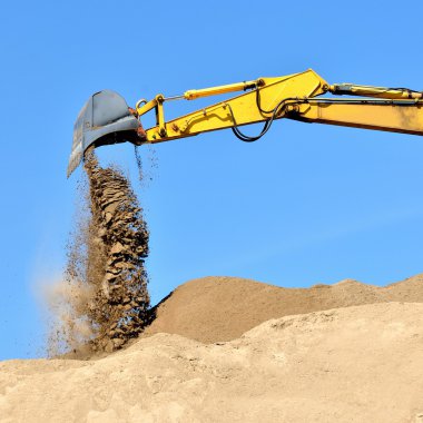 Yeni sarı ekskavatör kum tepeleri üzerinde çalışma
