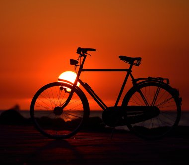 Kırmızı günbatımı karşı sahilde eski Hollanda retro Bisiklet