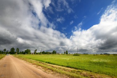 yeşil alan ve yol fırtınalı gökyüzü