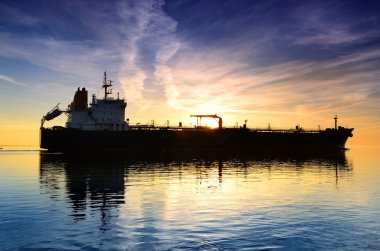 Kargo gemisi renkli günbatımında yelken açıyor.