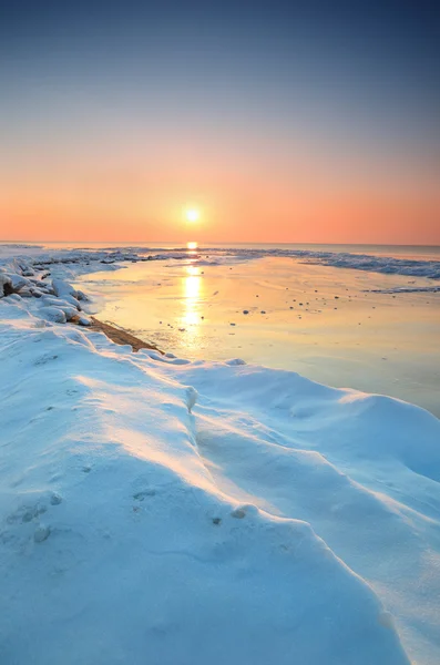 雪に覆われたバルト海海岸でカラフルな夕日 — ストック写真