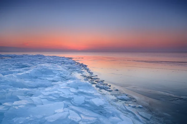 Färgstark solnedgång vid snöiga baltiska havet — Stockfoto
