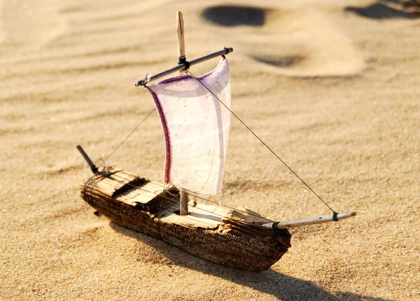 Wooden sail ship toy model in the sea sand — Stock Photo, Image