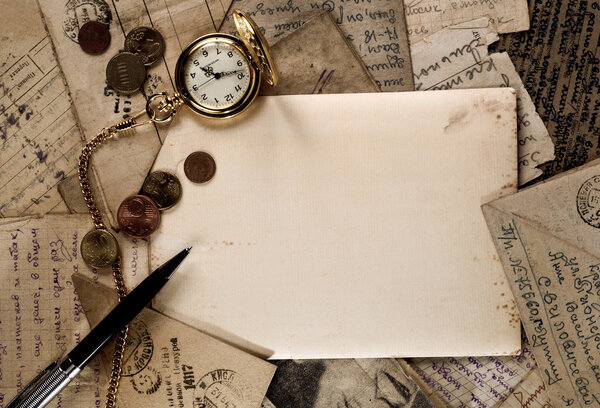 Винтажные карманные часы, ручка и деньги на текстуре старых букв
