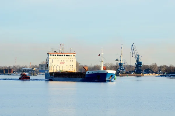 Nave da carico in partenza dal porto con faro sullo sfondo — Foto Stock