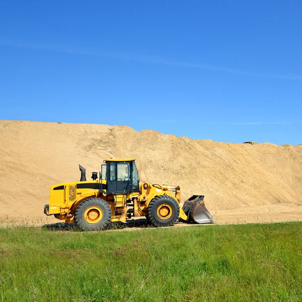 Excavadora trabajando en las dunas de arena — Stockfoto