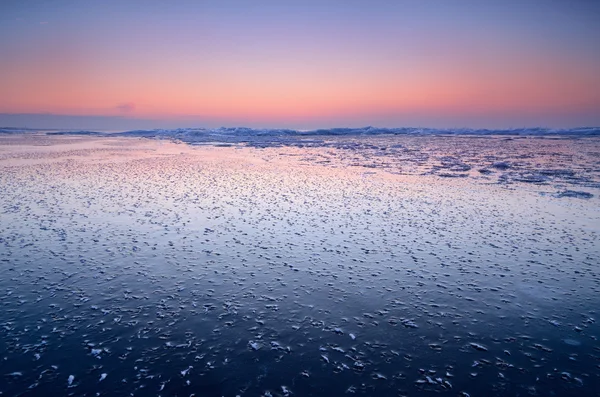 Красочный закат на снежном побережье Балтийского моря — стоковое фото