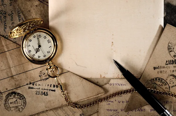 Vintage reloj de bolsillo y pluma en la textura de letras antiguas —  Fotos de Stock