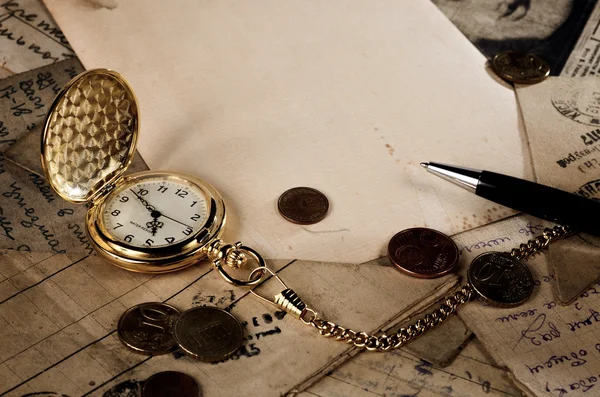 Reloj de bolsillo vintage, pluma y dinero en textura de letras antiguas —  Fotos de Stock