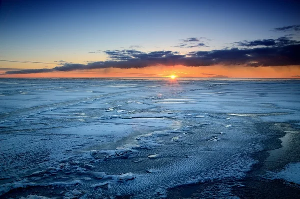 雪に覆われたバルト海海岸でカラフルな夕日 — ストック写真