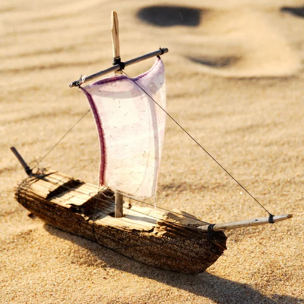 Wooden sail ship toy model in the sea sand — Stock Photo, Image