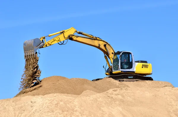 Nueva excavadora amarilla trabajando en dunas de arena —  Fotos de Stock