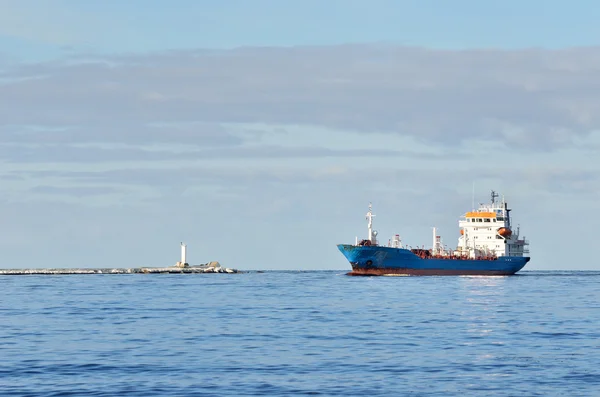 Buque de carga que entra en puerto con faro al fondo —  Fotos de Stock