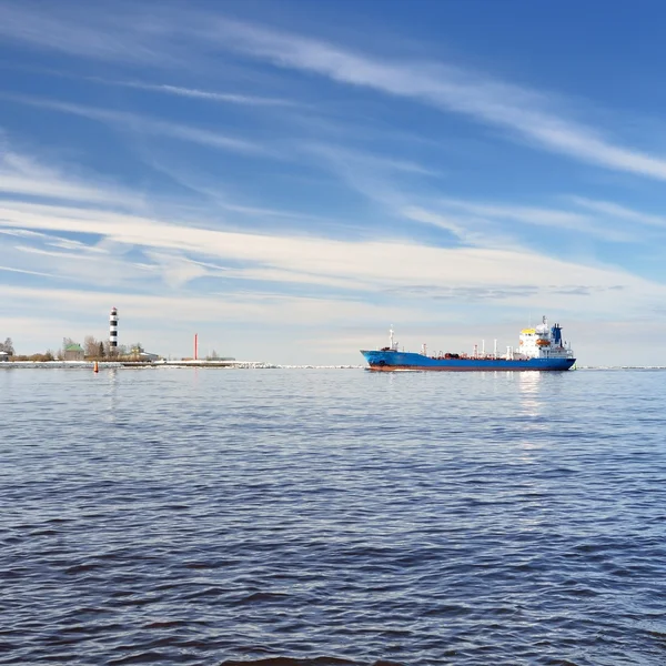 Frachtschiff im Hafen mit Leuchtturm im Hintergrund — Stockfoto