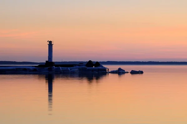 Vuurtoren in de zee bij de kleurrijke zonsondergang — Stockfoto