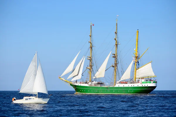 Old historical tall ship and a yacht with sails in blue sea — Stock Photo, Image