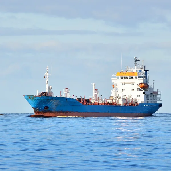 Nave da carico che entra in porto con faro sullo sfondo — Foto Stock