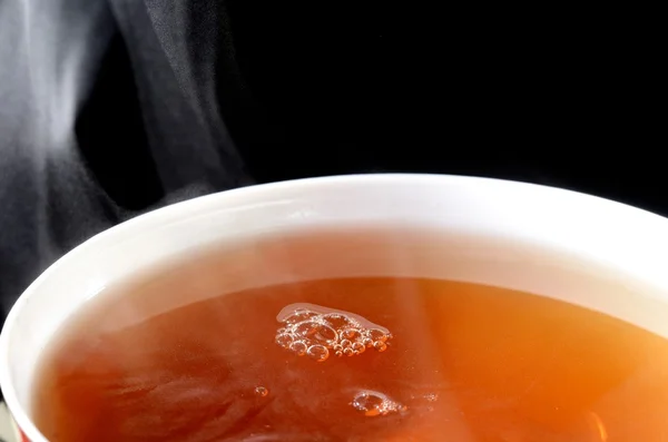 Nahaufnahme der Füllung Teetasse isoliert auf schwarz — Stockfoto