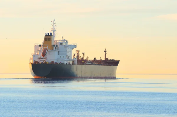 Navio de carga navegando ao pôr-do-sol colorido — Fotografia de Stock