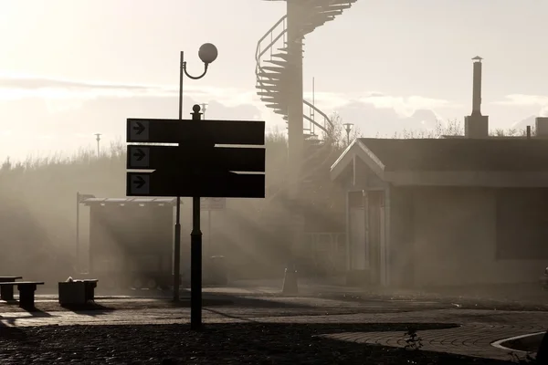 Заброшенная улица с туманом и солнечными лучами на закате — стоковое фото