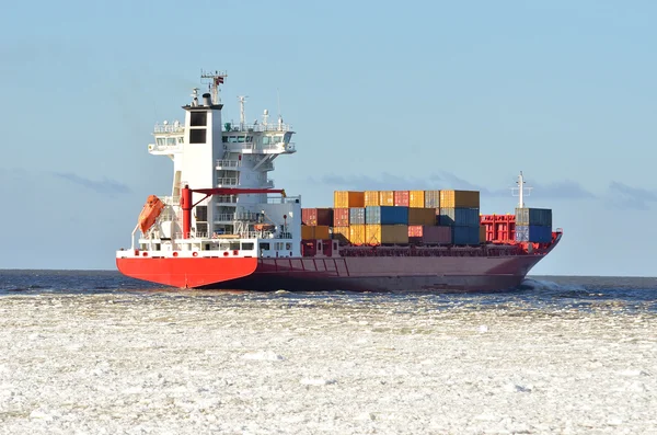 Cargo container ship sailing in sea full of ice in winter — Stock Photo, Image