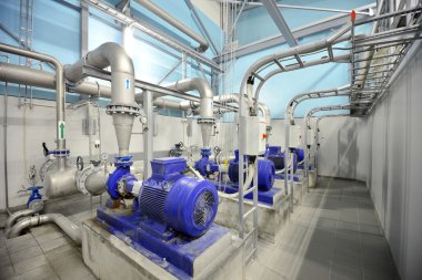 new shiny pipes and large pumps in industrial boiler room clipart