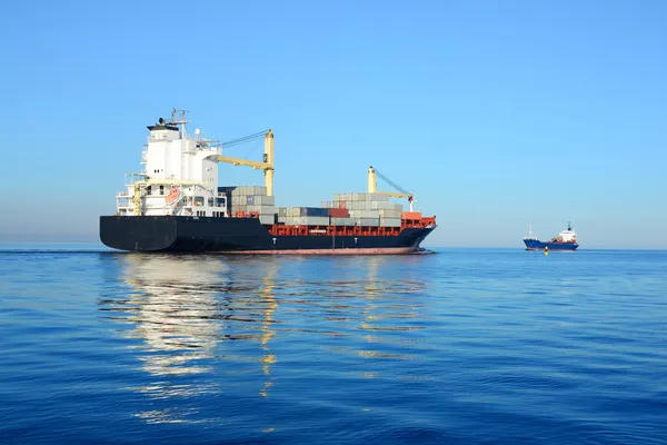 Nave container da carico e piccola nave da carico che naviga in acque tranquille — Foto Stock