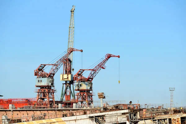 Port cargo cranes and ship fragment at the docks — Stock Photo, Image