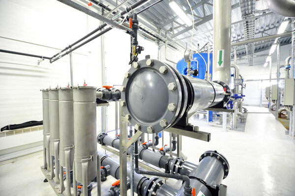 new shiny pipes and large pumps in industrial boiler room