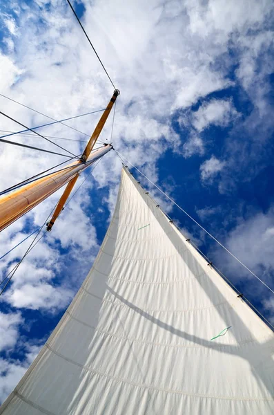 Мачта парусной яхты с белым парусом на темно-синем небе — стоковое фото