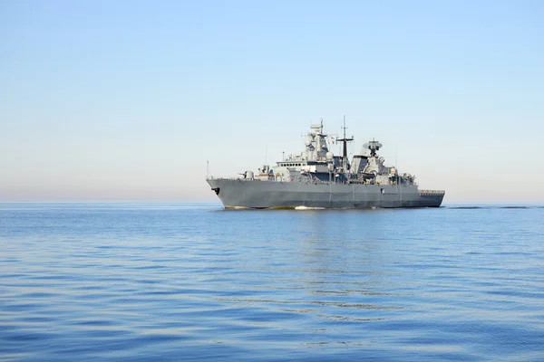 Серый современный военный корабль, плывущий в тихой воде Лицензионные Стоковые Фото