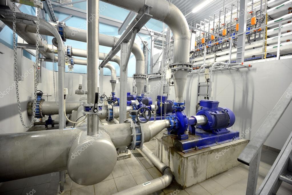 New shiny pipes and large pumps in industrial boiler room Stock Photo