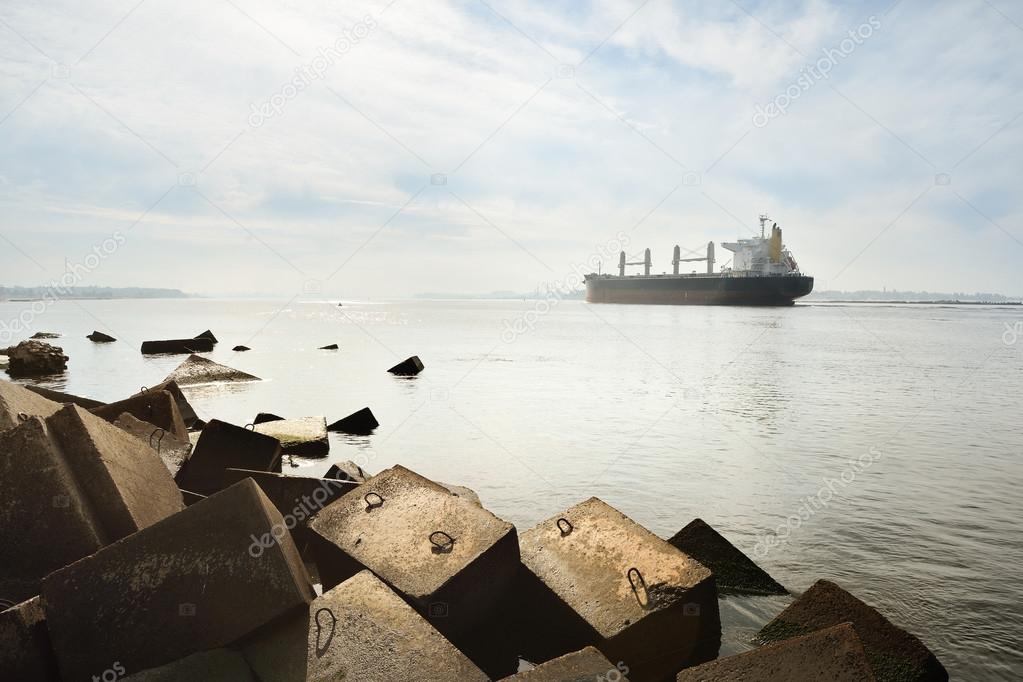 Large cargo ship sailing entering port of Riga