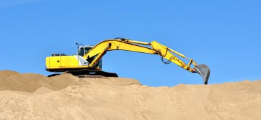 Yeni sarı ekskavatör kum tepeleri üzerinde çalışma