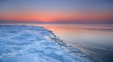 karlı Baltık Denizi sahilinde renkli günbatımı