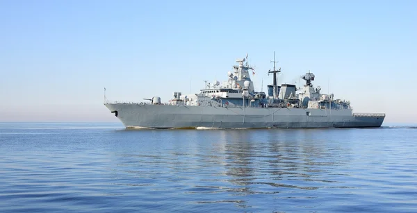 Сірий сучасний військовий корабель, що пливе у нерухомій воді — стокове фото